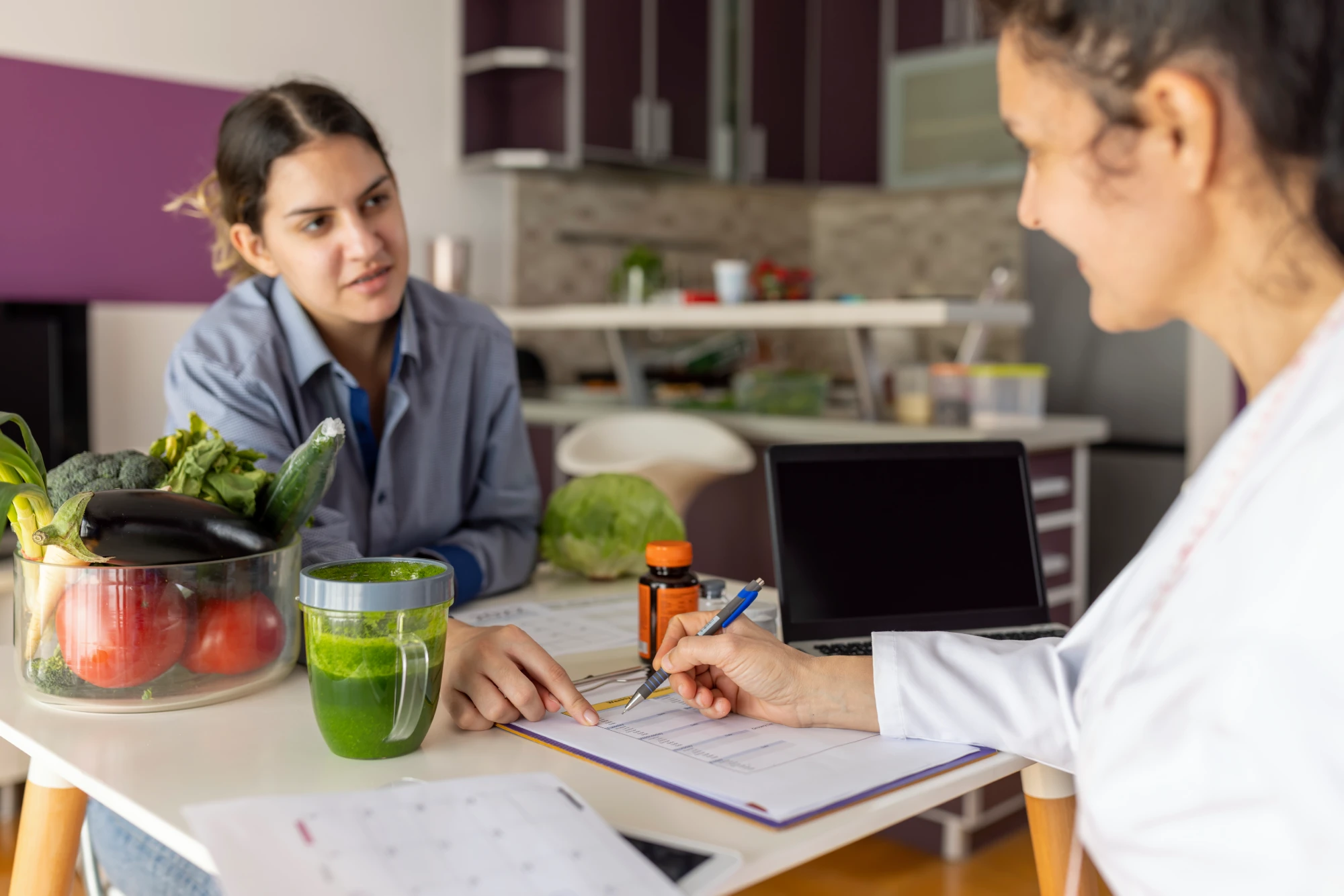 Two people discussing nutrition with vegetables nearby.