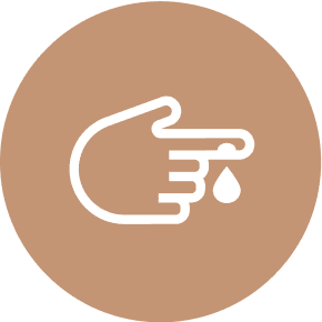 Finger with blood drop on brown circle.